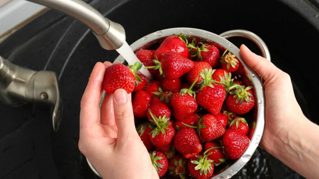 Rinsing strawberries under cold water